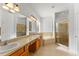 Bright bathroom featuring dual sinks, a soaking tub, and glass-enclosed shower at 3281 Pawleys N Loop, St Cloud, FL 34769