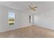 Bright bedroom featuring neutral tile flooring, a ceiling fan, and two windows at 3281 Pawleys N Loop, St Cloud, FL 34769