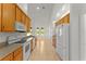 Galley kitchen featuring wooden cabinets, white appliances, tile flooring, and ample natural light at 3281 Pawleys N Loop, St Cloud, FL 34769