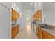 Bright kitchen with wooden cabinetry, tile floors, and white appliances in an open layout at 3281 Pawleys N Loop, St Cloud, FL 34769