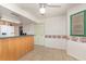 The kitchen area features tiled floors, a bright ceiling fan, and a breakfast bar with wood paneling at 360 Westchester Dr, Deland, FL 32724
