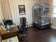 Office area with a desk, chair, computer, and a large birdcage near the window at 3609 Azurite Ct, Deland, FL 32724