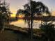 Serene waterfront view at sunset showing palm trees and beautiful reflections on the water at 3609 Azurite Ct, Deland, FL 32724