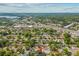 Panoramic aerial view of a neighborhood highlighting lush greenery, nearby lake and distant city skyline at 451 Hibiscus Rd, Casselberry, FL 32707