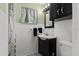 Cozy bathroom with patterned tile floors, white tiled walls, and a dark vanity sink at 451 Hibiscus Rd, Casselberry, FL 32707