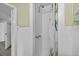 Bright bathroom with all-white tile shower and floors, and a patterned shower curtain at 451 Hibiscus Rd, Casselberry, FL 32707