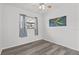 Bedroom with vinyl flooring, one window with neutral curtains, and an abstract painting at 451 Hibiscus Rd, Casselberry, FL 32707