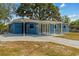 Bright blue single-story home featuring a covered carport and concrete driveway at 451 Hibiscus Rd, Casselberry, FL 32707