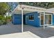 Side view of a bright blue single-story home with a covered carport and fenced yard at 451 Hibiscus Rd, Casselberry, FL 32707