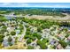 Expansive aerial view of neighborhood with pools and solar panels, showcasing green trees, a pond, and a nearby highway at 578 Darkwood Ave, Ocoee, FL 34761