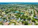 Aerial view of a sprawling residential community with ponds, green trees, homes with pools and solar panels, under a blue sky at 578 Darkwood Ave, Ocoee, FL 34761