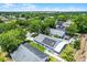 An aerial view of a home with solar panels, a screened patio, and a well-manicured lawn in a lush, green neighborhood at 578 Darkwood Ave, Ocoee, FL 34761