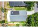An overhead view of a shingled roof with solar panels, a fenced yard, a patio, and mature trees at 578 Darkwood Ave, Ocoee, FL 34761