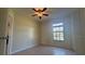 Bedroom showcasing a ceiling fan and window providing natural light, with tile flooring at 6654 Hiawassee Meadows Dr, Orlando, FL 32818