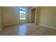 Well-lit bedroom featuring tile flooring, a window, and closet with bi-fold doors at 6654 Hiawassee Meadows Dr, Orlando, FL 32818