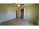 Bedroom features tile flooring, ceiling fan, and a closet with bi-fold doors at 6654 Hiawassee Meadows Dr, Orlando, FL 32818