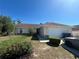 A single-story home with a tidy lawn and two-car garage on a sunny day at 6654 Hiawassee Meadows Dr, Orlando, FL 32818