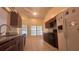 Stylish kitchen featuring granite counters, dark cabinets, and stainless steel appliances at 6654 Hiawassee Meadows Dr, Orlando, FL 32818