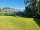 Spacious backyard with lush green grass, mature trees, and a glimpse of the screened-in pool area at 702 Palenci Ct, Winter Springs, FL 32708