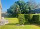 Large backyard featuring healthy green grass, privacy shrubs, and a screened-in pool in the distance at 702 Palenci Ct, Winter Springs, FL 32708