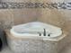 Bathroom featuring a corner soaking tub with travertine tile surround at 702 Palenci Ct, Winter Springs, FL 32708