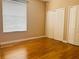Bedroom featuring wood floors, neutral paint and a bright window, paired with double closet doors at 702 Palenci Ct, Winter Springs, FL 32708