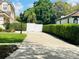 Long driveway leading to a gated home, surrounded by lush greenery and mature trees at 702 Palenci Ct, Winter Springs, FL 32708