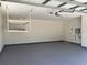 Clean garage with painted floor, overhead storage, and door to interior, perfect for organization at 702 Palenci Ct, Winter Springs, FL 32708