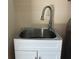 Functional laundry sink with modern faucet and cabinet, adding convenience to household chores at 702 Palenci Ct, Winter Springs, FL 32708