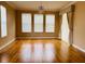 Bright and airy living room with hardwood floors, three windows, and elegant curtains at 702 Palenci Ct, Winter Springs, FL 32708