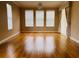 A living room featuring hardwood floors and three large windows at 702 Palenci Ct, Winter Springs, FL 32708
