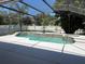 Beautiful screened-in pool area with a unique pool design and well-maintained deck at 702 Palenci Ct, Winter Springs, FL 32708