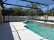 Inviting screened-in pool with a curved design, surrounded by lush landscaping and a spacious patio at 702 Palenci Ct, Winter Springs, FL 32708