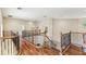 Spacious upstairs hallway overlooking the foyer with hardwood floors, wood and iron railings, and natural light at 755 Cranes Court, Maitland, FL 32751