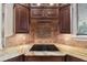 Gourmet kitchen features granite countertops, dark custom cabinets, tile backsplash, and modern cooktop at 755 Cranes Court, Maitland, FL 32751