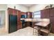 Cozy kitchen with dark wood cabinets, black appliances, and breakfast bar with seating at 755 Cranes Court, Maitland, FL 32751