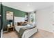 A stylish bedroom features a green accent wall, a comfortable bed, and ample natural light at 786 Mocking Jay Ln, St Cloud, FL 34771
