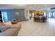 Open-concept living room flows into kitchen with stainless steel appliances and breakfast bar seating at 814 Vercelli St, Deltona, FL 32725