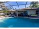 Screened-in pool area featuring a pool, spa, covered patio, and ample seating for relaxing at 814 Vercelli St, Deltona, FL 32725