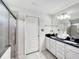 Bright bathroom featuring black countertop, dual sinks, shower, and ample lighting at 8961 Rhodes St, Kissimmee, FL 34747