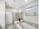 This bathroom features a shower with glass door, garden tub, and large window at 8961 Rhodes St, Kissimmee, FL 34747