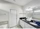 Bright bathroom featuring double sinks, black granite counters, and white cabinets and doors at 8961 Rhodes St, Kissimmee, FL 34747