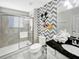 Bathroom featuring tiled shower, toilet, single sink vanity, and Mickey Mouse themed wallpaper at 8961 Rhodes St, Kissimmee, FL 34747