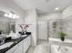The bright bathroom offers double sinks with granite countertops, a stand up shower and large soaking tub at 8961 Rhodes St, Kissimmee, FL 34747