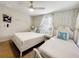 Charming bedroom featuring two twin beds with elegant wallpaper, white furniture, and ceiling fan at 8961 Rhodes St, Kissimmee, FL 34747