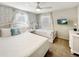 Bright bedroom with two twin beds, white furniture, ceiling fan, and elegant wallpaper at 8961 Rhodes St, Kissimmee, FL 34747
