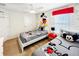Bedroom with twin beds, Mickey Mouse themed wallpaper, ceiling fan, and red valance at 8961 Rhodes St, Kissimmee, FL 34747