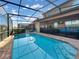 Beautiful backyard pool surrounded by brick and screen, with cozy patio seating available at 8961 Rhodes St, Kissimmee, FL 34747