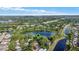Aerial view of property with pond, trees, and community at 9290 Lake Sharp Ct, Orlando, FL 32817