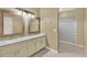 Bathroom featuring double sinks, vanity, and glass block shower at 9290 Lake Sharp Ct, Orlando, FL 32817